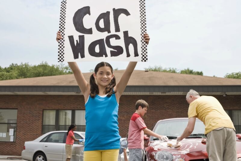 IMG: girl holding up sign for car wash
