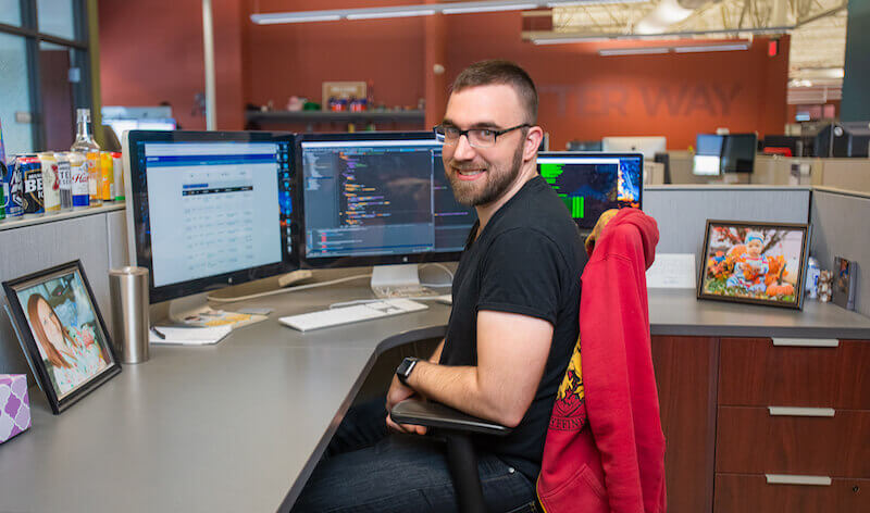 IMG: CJ sitting at his desk at Firespring