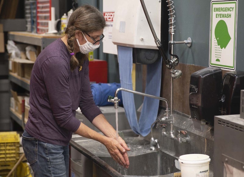 a print production specialist washing her hands.