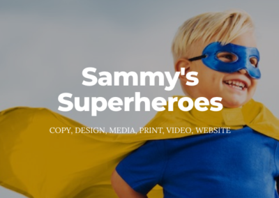 Young, smiling, blonde boy wearing blue superhero mask, blue shirt and yellow superhero cape. Text: Sammy's Superheroes; copy, design, media, print, video, website.
