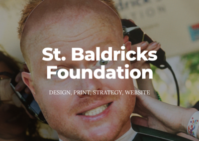 Man smiling as he is getting his head shaved. Text: St. Baldricks Foundation; design, print, strategy, website.