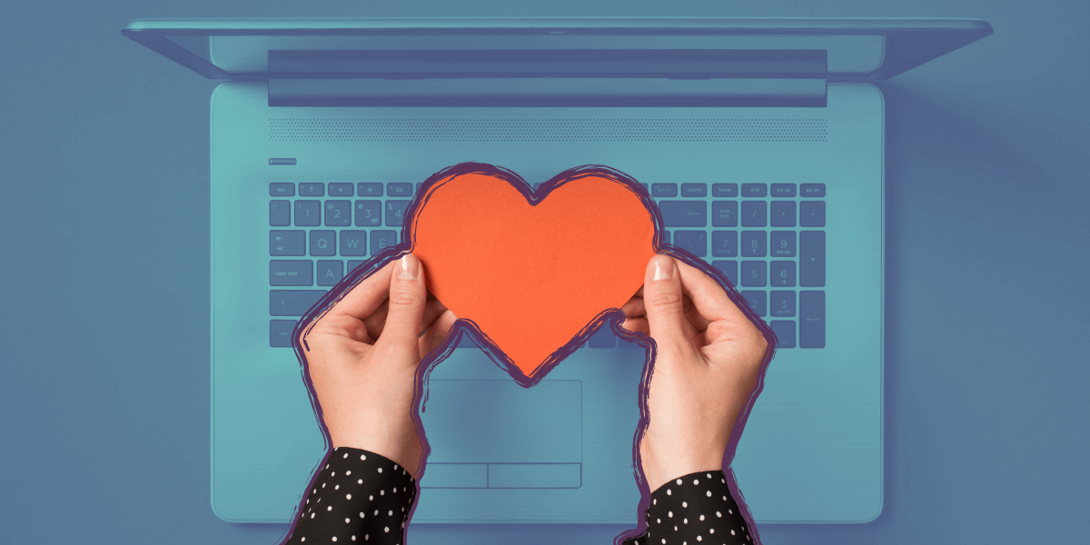 a person holding a heart over their computer