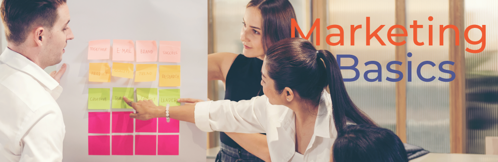 Group of 4 people pointing to multi-colored sticky notes on a wall while strategizing. Text on image reads: Marketing Basics.