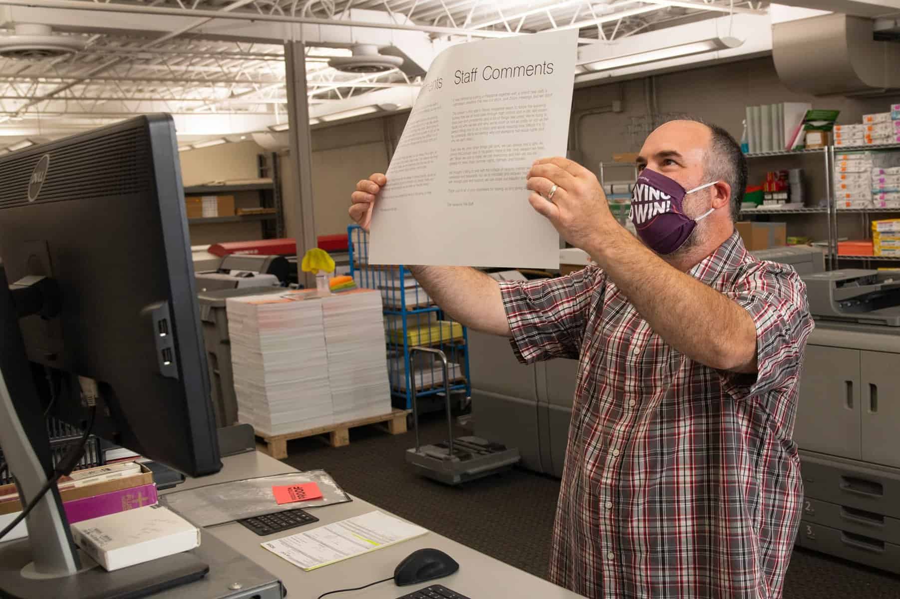 Man holding a print in a print warehouse