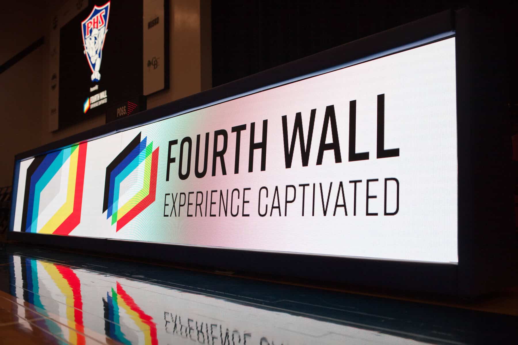 A digital display sign reads "FOURTH WALL EXPERIENCE CAPTIVATED" with colorful geometric graphics on the left side.